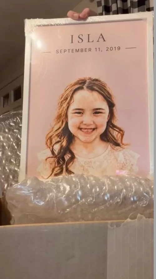Isla's portrait in a white frame being unboxed