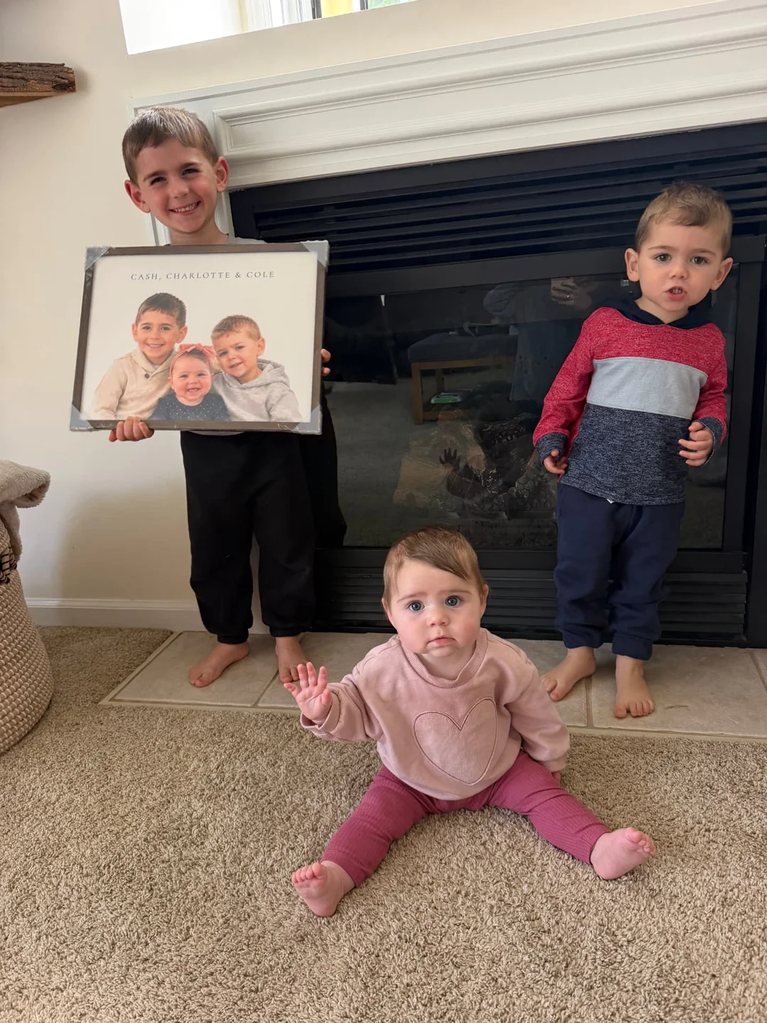 Three siblings holding their framed custom portrait